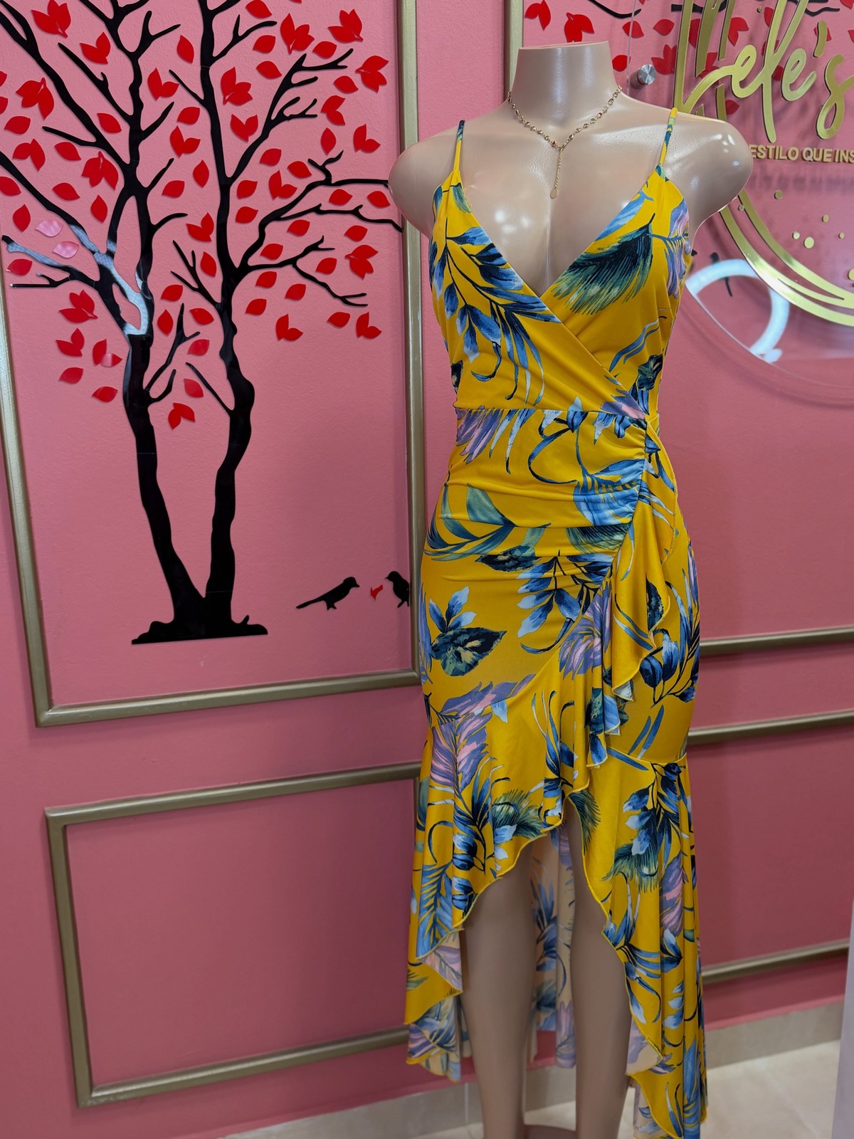 Vestido amarillo con estampado de hojas azules, tirantes finos y ruedo irregular